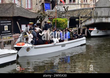 Touristen, die ein kleines Boot verlassen, nachdem sie das mittelalterliche Stadtzentrum von Brügge über die Kanäle besucht haben Stockfoto