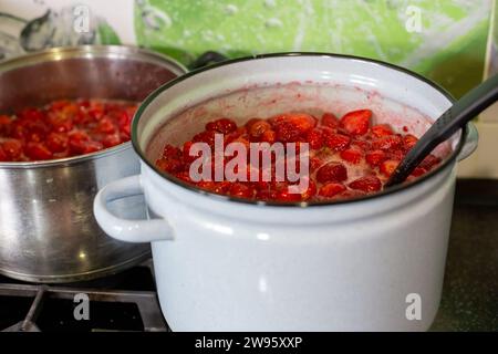 Saftige süße Erdbeermarmelade wird in Pfannen gekocht. Vorbereitungen für den Winter. Stockfoto