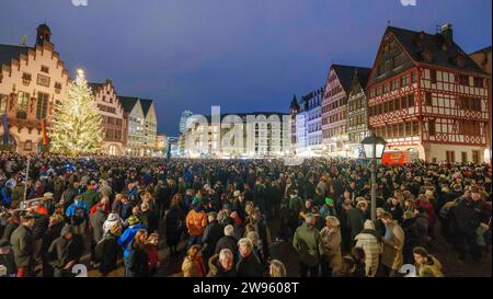 24. Dezember 2023, Hessen, Frankfurt/Main: Mehrere tausend Menschen stehen auf dem Römerberg zum Glockenläuten der Stadt. Während des traditionellen Frankfurter Stadtklingels am Heiligabend sind rund 50 Glocken aus den Innenstadtkirchen gleichzeitig zu hören. Foto: Andreas Arnold/dpa Stockfoto