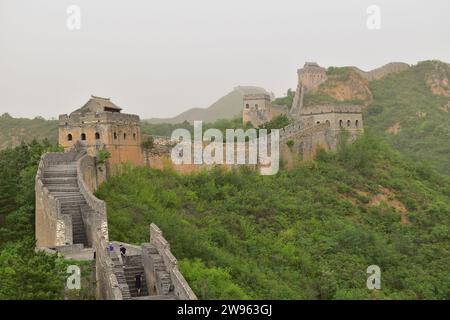 Touristen, die auf der Chinesischen Mauer im Touristengebiet der Chinesischen Mauer von Jinshanling spazieren Stockfoto