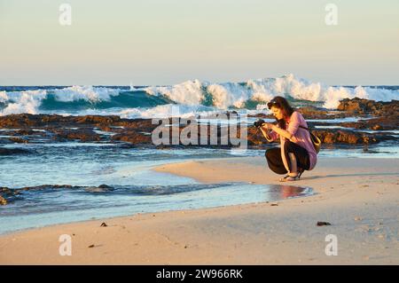 Frau fotografiert bei Sonnenuntergang am Strand von SES Platgetes in es Caló (Formentera, Pityusische Inseln, Balearen, Mittelmeer, Spanien) Stockfoto