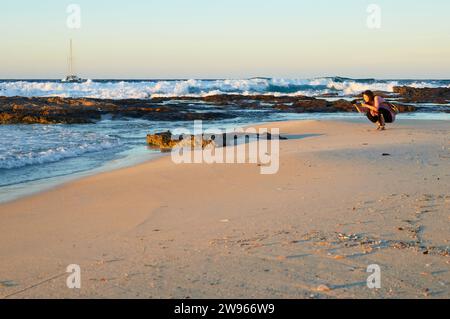 Frau fotografiert bei Sonnenuntergang am Strand von SES Platgetes in es Caló (Formentera, Pityusische Inseln, Balearen, Mittelmeer, Spanien) Stockfoto