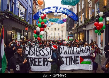 London, Großbritannien. Dezember 2023. Demonstranten in der Carnaby Street. Propalästinensische Demonstranten marschierten vor Weihnachten durch Londons Einkaufsviertel und forderten einen Waffenstillstand. Quelle: Vuk Valcic/Alamy Stockfoto