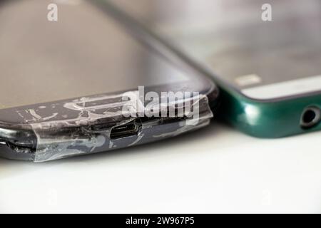 Es gibt ein altes Handytelefon mit Klebeband auf dem Tisch, Telefonreparatur, Handyreparatur Stockfoto