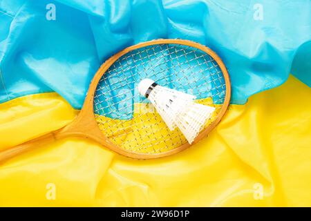 Badmintonschläger und Shuttlecock liegen auf der Flagge der Ukraine, Sport in der Ukraine Stockfoto