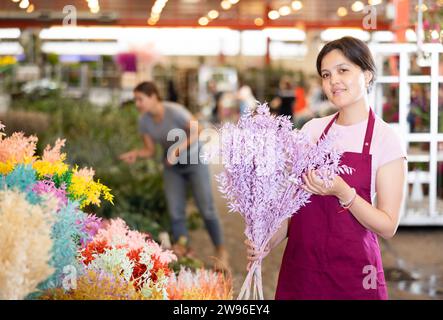 Porträt positiver Blumenmarktverkäufer mit Blumensträußen ruscus italie Stockfoto