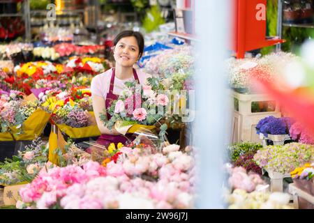 Porträt positiver weiblicher Blumenmarktverkäufer mit Blumensträußen Stockfoto