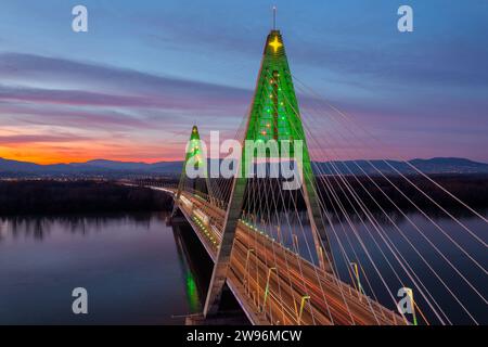 Aus der Vogelperspektive über die beleuchtete Megyeri-Brücke in einer seltenen weihnachtsdekoration bei Sonnenuntergang. Stockfoto
