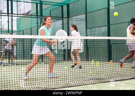 Porträt einer fröhlichen Tennisspielerin beim Gruppentraining auf dem Platz Stockfoto