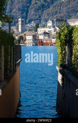 San Giulio Island im Orta-See im Piemont, Italien. Farbenfrohe Berge im Herbst, blaues Wasser, Kirche, Kloster und andere Gebäude Stockfoto