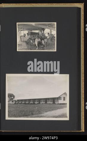 Gruppenporträt und Arbeiterhaus, Anonym, 1929 - 1930 Fotoalbum Magazin mit zwei Fotos: Gruppe in einem Schuppen mit Spielzeug und das Äußere eines Langhauses für mehrere Familienangestellte. Teil des Albums der Familie Guilonard über die Bauxitgewinnung in Moengo und Albina in Suriname in den Jahren 1929–1930. Fotografische Unterstützung von Suriname. Papiergelatine Silberdruck anonyme historische Personen, dargestellt in einer Gruppe, in einem Gruppenporträt. Ländliche Wohnungen, z. B. Landhaus, Villa, Ferienhaus Suriname. Albina. Moengo Stockfoto