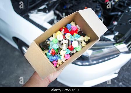 Kfz-Kunststoffklammern oder Kunststoffbefestigungen mit bunten Papierkarton für Auto, Autoersatzteilkonzept Stockfoto