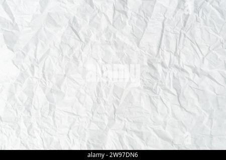 Zerknittertes oder zerknittertes weißes Schablonenpapier oder -Taschentuch nach Verwendung mit großem Kopierraum wird für die Hintergrundtextur verwendet. Stockfoto