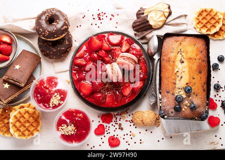 Dessert zum Valentinstag. Mothers Day Dessert. Tageskuchen für Damen. Verschiedene Süßigkeiten auf weißem Hintergrund. Draufsicht. Stockfoto