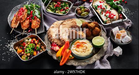 Nahöstliche oder arabische Gerichte auf schwarzem Hintergrund. Leckeres traditionelles Essen Konzept. Ansicht oben Stockfoto