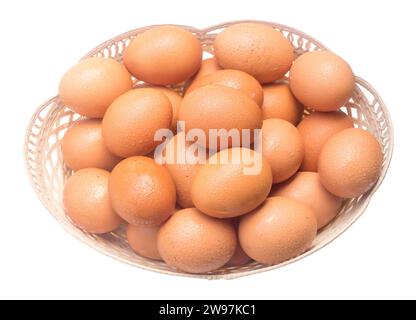 Frische Hühnereier mit Tropfen im Plastikkorb sind auf weißem Hintergrund mit Schneidepfad isoliert. Foto von oben Stockfoto