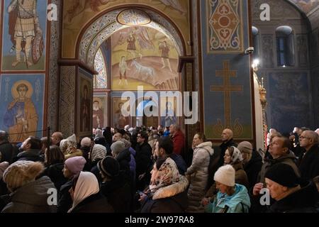 Kiew, Ukraine. Dezember 2023. Gläubige nehmen an einem Heiligabend der Ukrainisch-orthodoxen Kirche in der St. Teil Michaels goldene Kathedrale (Mykhailivskyi Zolotoverkhyi) in Kiew. Im Gegensatz zu früheren Jahren, als die Ukraine am 7. Januar zusammen mit anderen postsowjetischen Ländern Weihnachten feierte, wird sie sich dieses Jahr mit Europa verbinden und Weihnachten am 25. Dezember feiern. Quelle: SOPA Images Limited/Alamy Live News Stockfoto