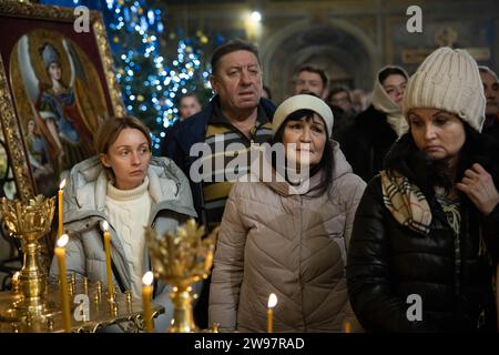 Kiew, Ukraine. Dezember 2023. Gläubige nehmen an einem Heiligabend der Ukrainisch-orthodoxen Kirche in der St. Teil Michaels goldene Kathedrale (Mykhailivskyi Zolotoverkhyi) in Kiew. Im Gegensatz zu früheren Jahren, als die Ukraine am 7. Januar zusammen mit anderen postsowjetischen Ländern Weihnachten feierte, wird sie sich dieses Jahr mit Europa verbinden und Weihnachten am 25. Dezember feiern. Quelle: SOPA Images Limited/Alamy Live News Stockfoto