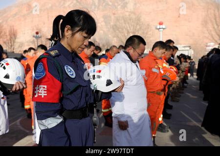 Jishishan, Chinas Provinz Gansu. Dezember 2023. Die Menschen zollen während einer Gedenkfeier für die Erdbebenopfer auf einem Platz in Dahejia Township im Jishishan County, nordwestchinesische Provinz Gansu, 25. Dezember 2023 eine stille Anerkennung. Ein Erdbeben der Stärke 6,2 erschütterte das Jishan County in der Provinz Gansu am 18. Dezember. Quelle: Fang Xin/Xinhua/Alamy Live News Stockfoto