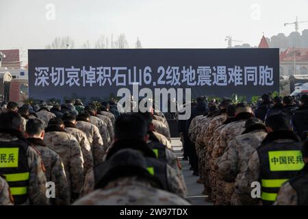 Jishishan, Chinas Provinz Gansu. Dezember 2023. Die Menschen zollen während einer Gedenkfeier für die Erdbebenopfer auf einem Platz in Dahejia Township im Jishishan County, nordwestchinesische Provinz Gansu, 25. Dezember 2023 eine stille Anerkennung. Ein Erdbeben der Stärke 6,2 erschütterte das Jishan County in der Provinz Gansu am 18. Dezember. Quelle: Fang Xin/Xinhua/Alamy Live News Stockfoto