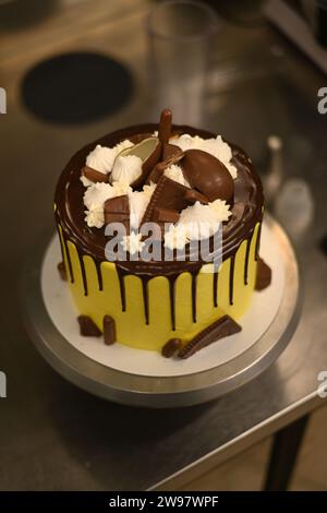 Konditor glatt Formen Sie gelber tropfender, mattierter, aufgeschlagener, dunkler Schokoladenkuchen mit hoher Auflösung Stockfoto