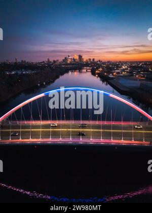 Ein atemberaubendes Bild der Lowry Avenue Bridge in Minneapolis, Minnesota, beleuchtet in einer herrlichen Auswahl an blauen und roten Lichtern bei Sonnenuntergang Stockfoto