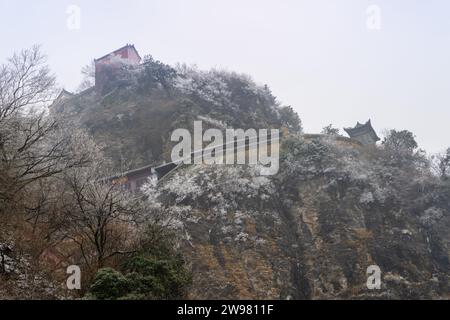 Antike Gebäude in Chinas Wudang-Bergen sind elegant mit einer Schneeschicht dekoriert und bieten eine harmonische Mischung aus Natur und Architektur. Stockfoto