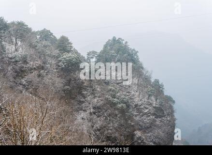 Antike Gebäude in Chinas Wudang-Bergen sind elegant mit einer Schneeschicht dekoriert und bieten eine harmonische Mischung aus Natur und Architektur. Stockfoto