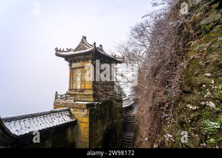 Antike Gebäude in Chinas Wudang-Bergen sind elegant mit einer Schneeschicht dekoriert und bieten eine harmonische Mischung aus Natur und Architektur. Stockfoto