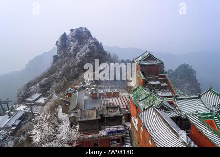 Antike Gebäude in Chinas Wudang-Bergen sind elegant mit einer Schneeschicht dekoriert und bieten eine harmonische Mischung aus Natur und Architektur. Stockfoto