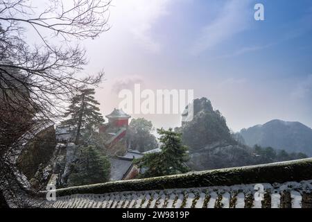 Antike Gebäude in Chinas Wudang-Bergen sind elegant mit einer Schneeschicht dekoriert und bieten eine harmonische Mischung aus Natur und Architektur. Stockfoto