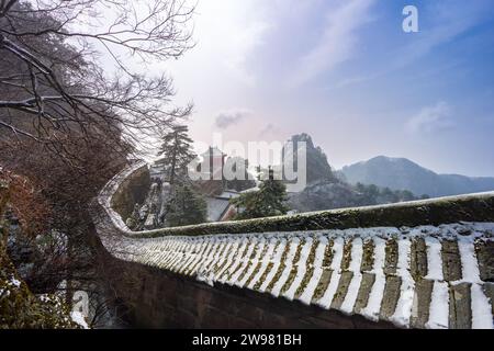 Antike Gebäude in Chinas Wudang-Bergen sind elegant mit einer Schneeschicht dekoriert und bieten eine harmonische Mischung aus Natur und Architektur. Stockfoto