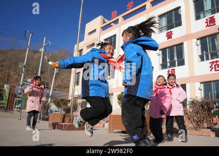 Jishishan, Chinas Provinz Gansu. Dezember 2023. Die Schüler spielen Spiele während einer Klassenpause in einer Grundschule in der Gemeinde Liugou im Jishishan County, nordwestchinesische Provinz Gansu, 25. Dezember 2023. Grund- und Sekundarschulen in den von Erdbeben betroffenen Gebieten von Jishishan begannen am Montag nach einer Sicherheitsüberprüfung wieder den Unterricht aufzunehmen. Quelle: Chen Bin/Xinhua/Alamy Live News Stockfoto