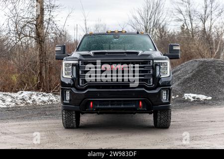 Ein schwarzer GMC-Lkw auf einem Parkplatz, umgeben von Bäumen Stockfoto