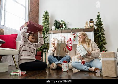 Freunde lachen in einem Urlaub mit Geschenken Stockfoto