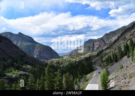 Der Million Dollar Highway schlängelt sich durch das Tal, umgeben von den Rocky Mountains in der Nähe der Bear Creek Falls Stockfoto