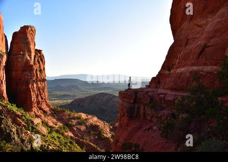 Person auf einem Steinvorsprung mit Blick auf die Wüstenlandschaft von Arizona vom Cathedral Rock in Sedona Stockfoto