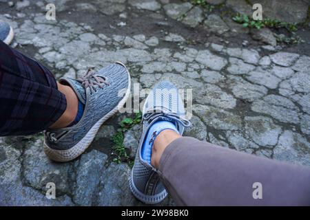 Am 23. Februar 2023 tragen zwei Frauenfüße graue Schuhe in Wonobosobo, Indonesien. Stockfoto