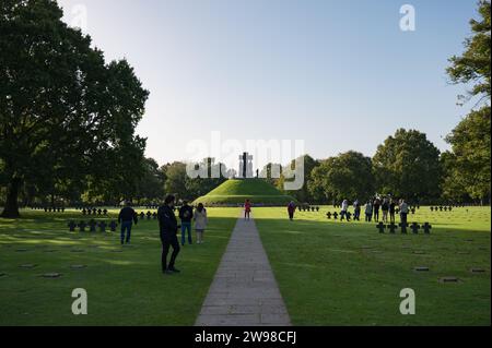 Gerades und symmetrisches Foto des deutschen Friedhofs La Cambe in der Normandie, mit Besuchern der Gräber Stockfoto