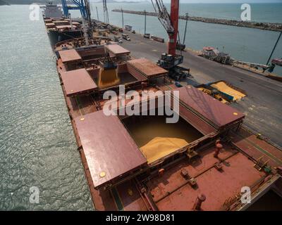 Luftaufnahme von zwei Kränen, die Sojabohnen auf ein Frachtschiff laden, mit vollem Schiffsraum, bereit für den Export Stockfoto