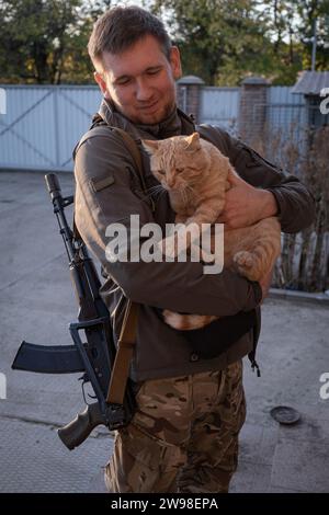 Ein freiwilliger Soldat, der eine Katze im Arm hält. Am 10. September 2023 kündigten die ukrainischen Behörden die obligatorische Evakuierung von Siedlungen im Gebiet von Kupjansk am Ostufer des Oskol an, einschließlich Teilen von Kupjansk selbst. Weniger als ein Jahr nach der Befreiung durch die ukrainische Armee wurden die Stadt und ihre Vororte, die ein wichtiger Eisenbahnknotenpunkt und eine direkte Verbindung zu Russland darstellen, wieder zu einem wichtigen militärischen Ziel, das durch die russische Offensive gefährdet wurde. Stockfoto