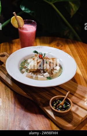 Gesundes Essen serviert auf einer Platte und Erfrischungen auf einem Holztisch. Stockfoto