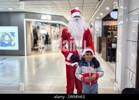 Kathmandu, Bagmati, Nepal. Dezember 2023. Ein als Weihnachtsmann verkleideter Mann posiert am 25. Dezember 2023 mit einem Jungen zur Weihnachtsfeier in einem Einkaufszentrum in Kathmandu, Nepal. (Kreditbild: © Sunil Sharma/ZUMA Press Wire) NUR REDAKTIONELLE VERWENDUNG! Nicht für kommerzielle ZWECKE! Stockfoto