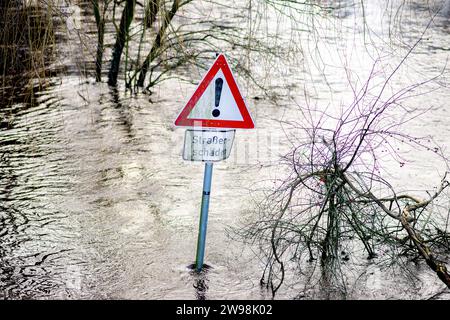 Oldenburg, Deutschland. Dezember 2023. Ein Schild steht im Wasser auf einem überfluteten Wander- und Radweg entlang des Osternburger Kanals. Aufgrund der Hochwassersituation hat die Stadt Oldenburg den Zugang zu Deichgebieten und Wegen verboten. Die Hochwassersituation ist in vielen Regionen Niedersachsens über die Weihnachtsferien weiterhin angespannt. Quelle: Hauke-Christian Dittrich/dpa/Alamy Live News Stockfoto