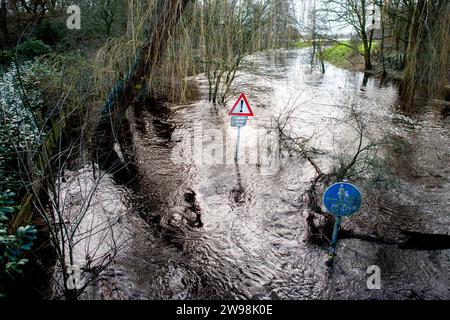 Oldenburg, Deutschland. Dezember 2023. Der Osternburger Kanal ist im Stadtteil Kreyenbrück über seine Ufer geplatzt und hat einen Wander- und Radweg überflutet. Aufgrund der Hochwassersituation hat die Stadt Oldenburg ein Einfahrverbot für Deichgebiete und die dortigen Wege erlassen. Die Hochwassersituation wird in vielen Regionen Niedersachsens über die Weihnachtsferien angespannt bleiben. Quelle: Hauke-Christian Dittrich/dpa/Alamy Live News Stockfoto