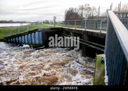 Oldenburg, Deutschland. Dezember 2023. Das Wasser wird von der Hunte an einer Schleuse in den Osternburger Kanal abgeleitet. Aufgrund der Hochwassersituation hat die Stadt Oldenburg den Zugang zu Deichgebieten und Wegen verboten. Die Hochwassersituation ist in vielen Regionen Niedersachsens über die Weihnachtsferien weiterhin angespannt. Quelle: Hauke-Christian Dittrich/dpa/Alamy Live News Stockfoto