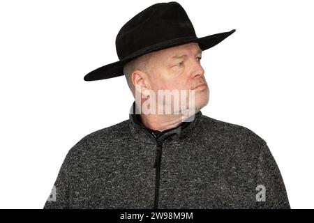 Seriöser Kaukasier mittleren Alters in getragenem Cowboy Hut, der zur Seite schaut - isoliertes Porträt auf weißem Hintergrund Stockfoto