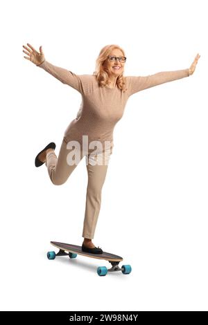 Reife Frau, die Skateboard fährt und Arme auf weißem Hintergrund verteilt Stockfoto