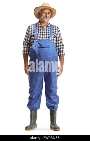 Reifer Bauer in Overalls mit Gummistiefeln und Strohhut isoliert auf weißem Hintergrund Stockfoto