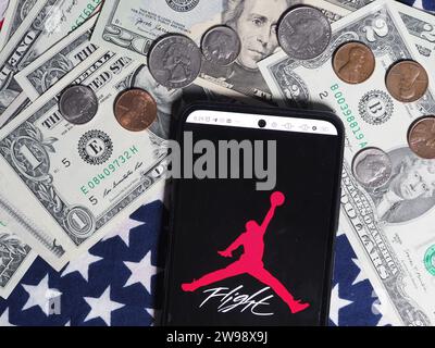 Deutschland. Dezember 2023. In dieser Fotoabbildung ist ein Air Jordan Logo auf einem Smartphone mit US-Dollar-Banknoten und -Münzen im Hintergrund zu sehen. Quelle: SOPA Images Limited/Alamy Live News Stockfoto